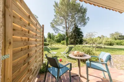 a patio with chairs and a table and a fence at Belambra Clubs L'Isle Sur La Sorgue - Domaine De Mousquety in LʼIsle-sur-la-Sorgue