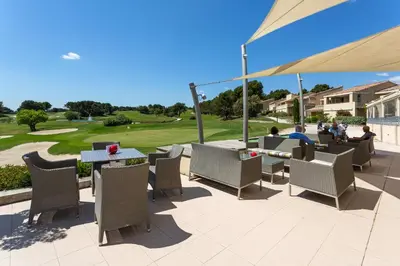 a patio with chairs and tables and an umbrella at Madame Vacances Domaine du Provence Country Club Service Premium in Saumane-de-Vaucluse