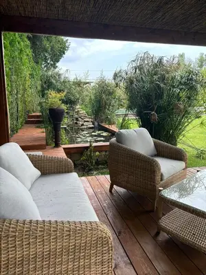 a patio with wicker chairs and a table on a deck at Le Mas des Mirabelles in Cabannes