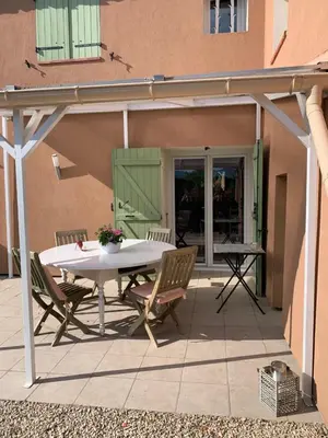 a patio with a table and chairs and a building at Chambre d'hôtes Le Cèdre in Apt