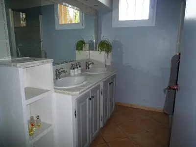 a bathroom with two sinks and a mirror at L'Atelier des Coudelières in Le Thor