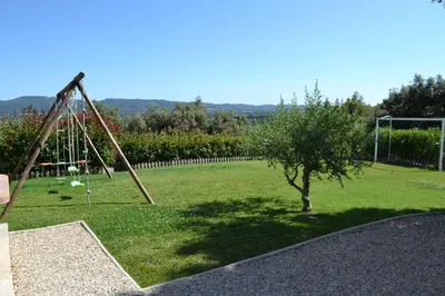 a swing set in a field with a tree at La cubaine in Puget