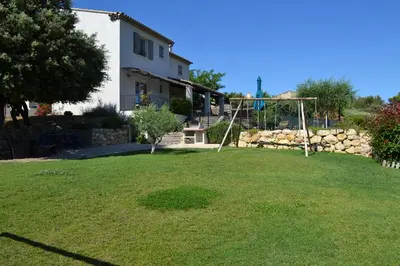 a yard with a swing set in a yard at La cubaine in Puget
