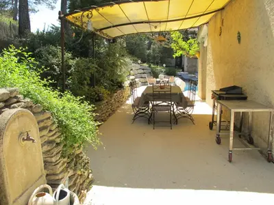 a patio with a table and chairs under a yellow umbrella at Holiday Home Luberon Vidauque by Interhome in Cavaillon