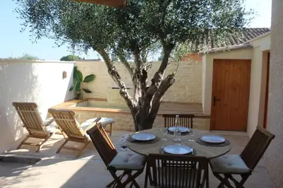 a table and chairs on a patio with a tree at Maison de charme à Mérindol + Jardin in Mérindol