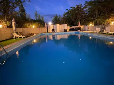 a large swimming pool with blue water at night at Hotel Carina in Apt