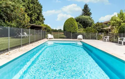 a swimming pool in a backyard with a fence at Cozy Home In Pernes Les Fontaines in Pernes-les-Fontaines