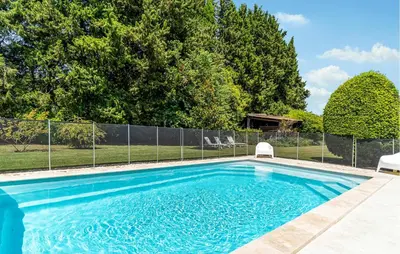 a swimming pool with a fence and trees at Cozy Home In Pernes Les Fontaines in Pernes-les-Fontaines
