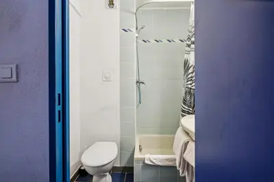 a small bathroom with a toilet and a shower at Hôtel AKENA Chateaurenard - Parc des Expositions Avignon in Châteaurenard