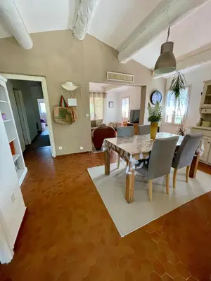 a living room with a dining room table and chairs at La belle histoire gîte Luberon in Bédoin