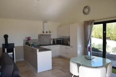 a kitchen with white cabinets and a glass table at Le Mazet d'Emilia avec jardin et piscine privés in Cucuron