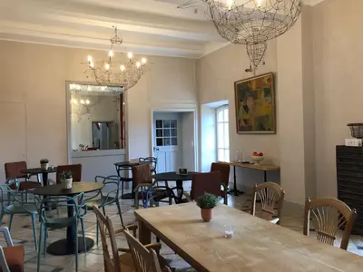 a dining room with tables and chairs and chandeliers at Bastide de Ganay - Saint Jérôme in Aix-en-Provence