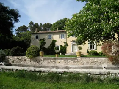 a large yellow house with a stone wall at Bastide de Ganay - Saint Jérôme in Aix-en-Provence