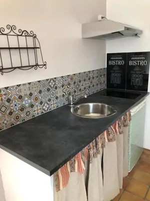 a kitchen counter top with a sink and towels at Le clos des vergers in LʼIsle-sur-la-Sorgue