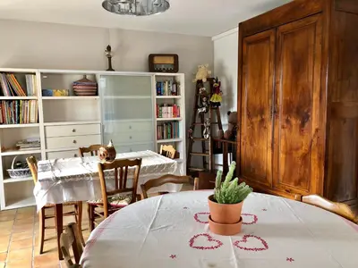 a living room with a table and chairs and a dining room at Le clos des vergers in LʼIsle-sur-la-Sorgue
