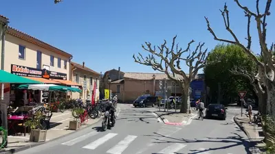 a person riding a bike down a city street at Villa Chapperon in Bédoin