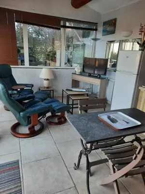 a living room with chairs and a table and a refrigerator at un lit en provence in Éguilles