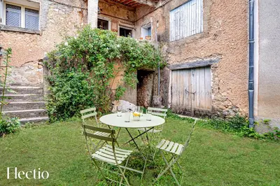 a table and chairs in a yard next to a building at Mas La Miellerie - Charme Authentique et Nature in Simiane-la-Rotonde