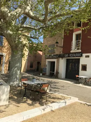 a table and chairs under a tree in front of a building at 40 Rue du Ventoux in Bédoin