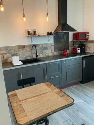 a restaurant with wooden tables and chairs and a counter at Les lofts in LʼIsle-sur-la-Sorgue