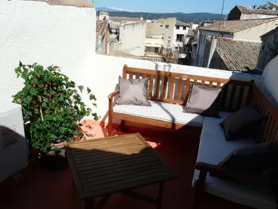 a small balcony with a bench and a table at Miel de Lavande in LʼIsle-sur-la-Sorgue
