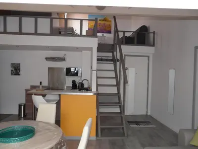 a living room with a loft bed and a table at Miel de Lavande in LʼIsle-sur-la-Sorgue