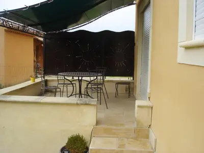 a patio with a table and chairs on a balcony at Villa confortable avec piscine privée à Saint-Saturnin-lès-Apt in Croagnes