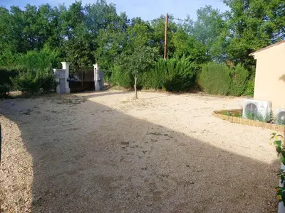 a gravel driveway with a tree in the middle at Villa confortable avec piscine privée à Saint-Saturnin-lès-Apt in Croagnes