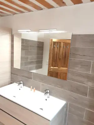 a bathroom with two sinks and a large mirror at Villa confortable avec piscine privée à Saint-Saturnin-lès-Apt in Croagnes