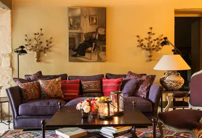 a living room with a purple couch and a table at Villa Grenache, La Bastide de Marie, Villa avec services in Ménerbes
