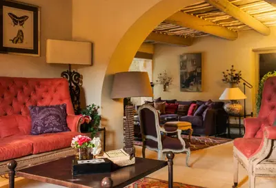 a living room with a red couch and chairs at Villa Grenache, La Bastide de Marie, Villa avec services in Ménerbes