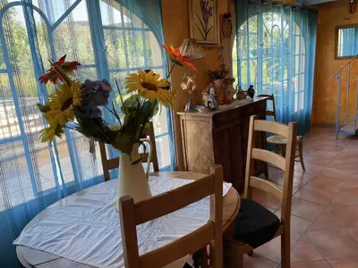 a room with a table with a vase of flowers on it at Bastide Les Basses Royères in Robion en Luberon