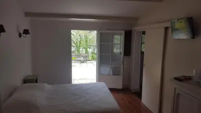 a bedroom with a bed and a sliding glass door at Chambres d'hôtes de la gardy in Eyragues