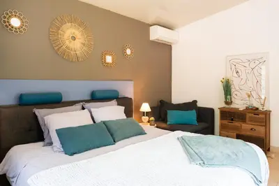 a bedroom with a large bed with blue and white pillows at Maison d’Etienne in Lacoste