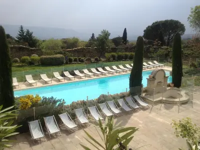 a pool with chaise lounge chairs and a bunch ofitures at Au bastidon de Gordes in Gordes