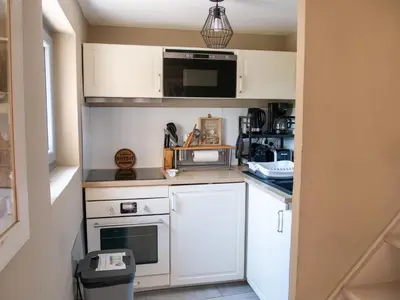 a small kitchen with white cabinets and a microwave at Location Bonnieux Provence in Bonnieux