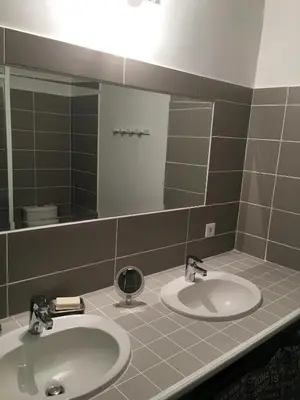 a bathroom with two sinks and a large mirror at Maison de village in Velleron