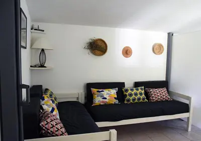a couch in a living room with pillows on it at La Maison Des Invites in Pernes-les-Fontaines