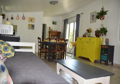 a living room with a couch and a dining room at La Maison Des Invites in Pernes-les-Fontaines