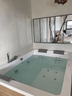 a bath tub with water in it in a room at Maison Florence Ivakno in Coudoux