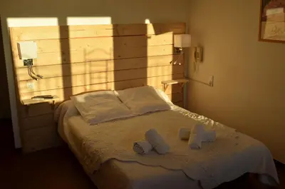 a bedroom with a bed with two towels on it at Logis Hôtel Panoramique César in Bonnieux