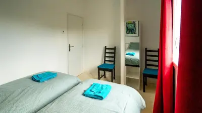 a small bedroom with two beds and a mirror at Les Terrasses de Cascavelle in Blauvac