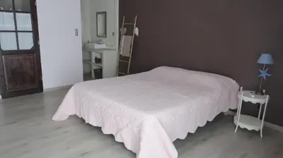 a bedroom with a bed with a white bedspread at Safranière des Sorgues in Le Thor