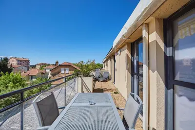 a patio with a table and chairs on a balcony at Appart'hôtel Odalys City - Aix en Provence Centre Rotonde in Aix-en-Provence