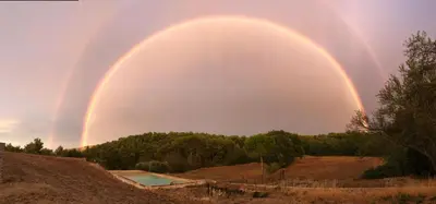 a double rainbow in the sky over a pool at Chut ! c'est ici in Venelles
