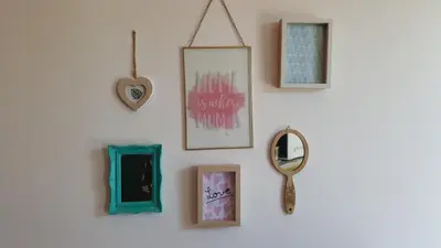 a wall with pictures and a mirror on it at Le Mas Romantique avec Jacuzzi et Sauna privé in Sénas