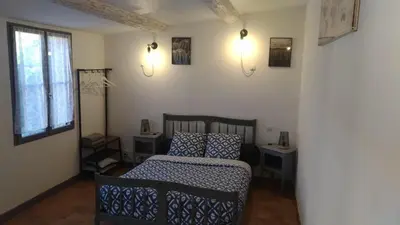 a bedroom with a bed and two tables and a window at L'ilot de Carpentras in Carpentras