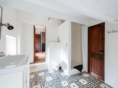 a white bathroom with a black and white tiled floor at Villa in Saignon with Pool and Scenic Views in Ménerbes