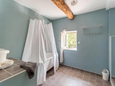 a bathroom with a white shower curtain and a window at Villa in Saignon with Pool and Scenic Views in Ménerbes