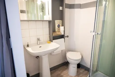 a small bathroom with a sink and a toilet at Le palais, hôtel - restaurant in Apt